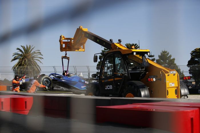 Oficiales de pista retiran del circuito el coche dañado de Alex Albon, Williams FW45