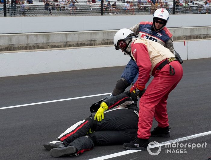 El personal médico ayuda al miembro del equipo herido cuando Jordan King, Rahal Letterman Lanigan Racing Honda, se deslizó dentro de su box y pegó un neumático que lo golpeó