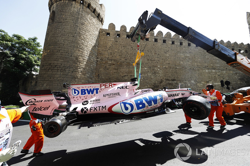 Oficiales de pista remueven el coche chocado de Sergio Pérez Sahara Force India F1 VJM10, en una grúa