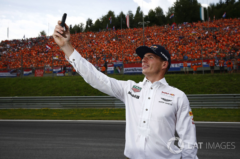 Max Verstappen, Red Bull, takes a photo, his Dutch fans in the background.