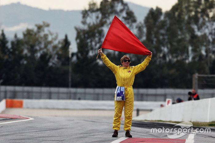 Red flag held by a marshal at the end of the pit lane