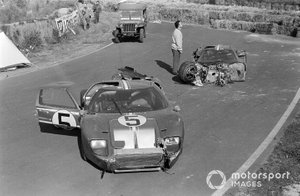 Los coches dañados de Frank Gardner, Roger McCluskey, Holman Moody Racing, Ford GT40 Mk2B, y Mario Andretti, Lucien Bianchi, Holman Moody Racing, Ford GT40 Mk4, con un Jeep Willys del servicio de bomberos
