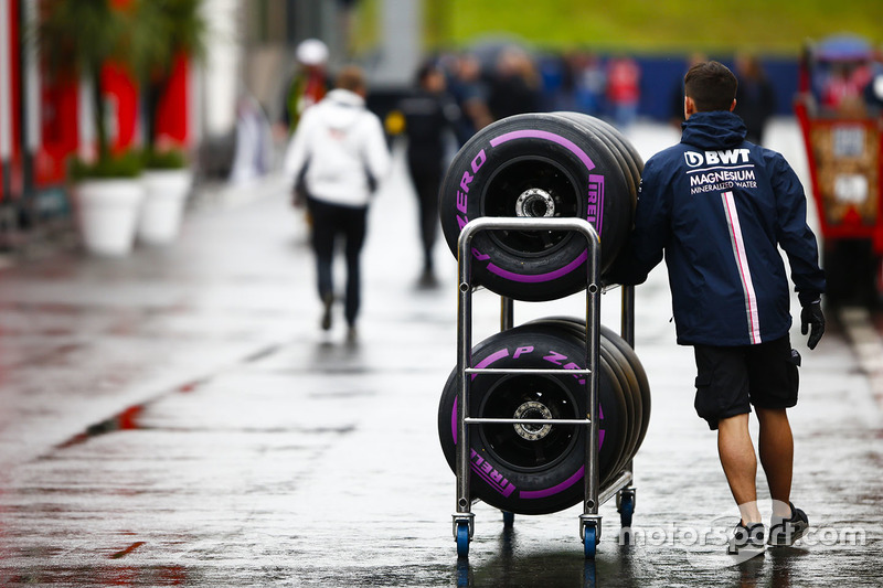Un meccanico Force India attraversa il paddock con degli pneumatici Pirelli