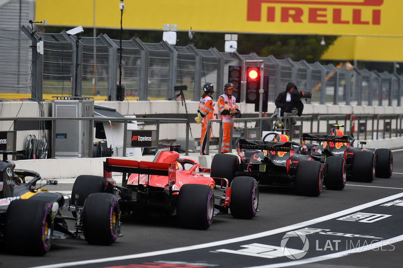 Los coches hacen cola en la luz roja en el carril de boxes