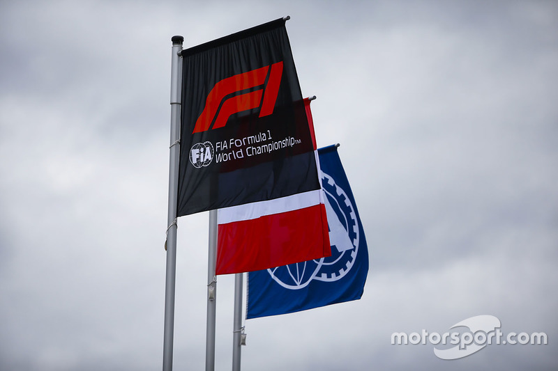 The Austrian flag flies alongside others displaying the Formula 1 and FIA logos