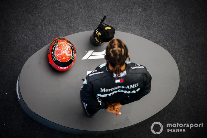 Lewis Hamilton, Mercedes-AMG F1, 1ª posición, en el podio con su trofeo y el casco de Michael Schumacher