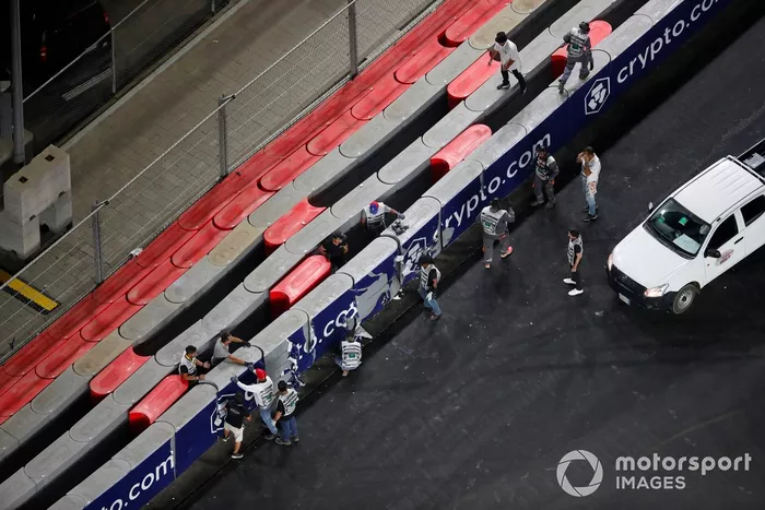 Los oficiales de pista reparan una barrera tras el accidente de Mick Schumacher, Haas VF-21
