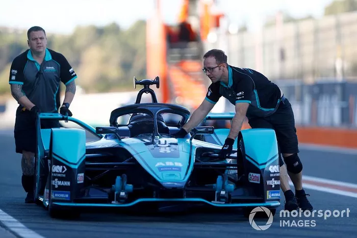 Mechanics push a Jaguar I-Type 4 back into the garage