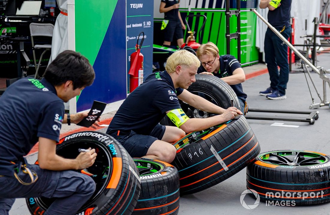 Los miembros del equipo Envision Racing preparan los neumáticos