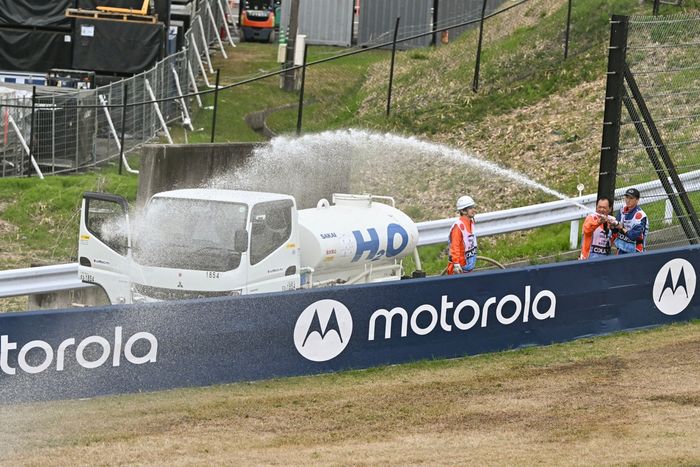 Los alguaciles rocían agua para humedecer la hierba y evitar incendios en las vías.