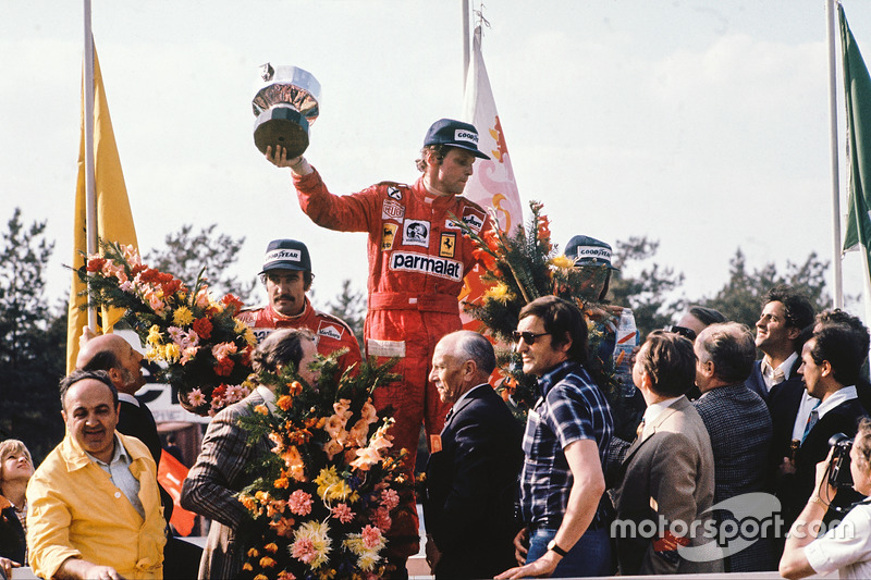 Race winner Niki Lauda, Ferrari, celebrates with second place Clay Regazzoni, Ferrari and third place Jacques Laffite on the podium