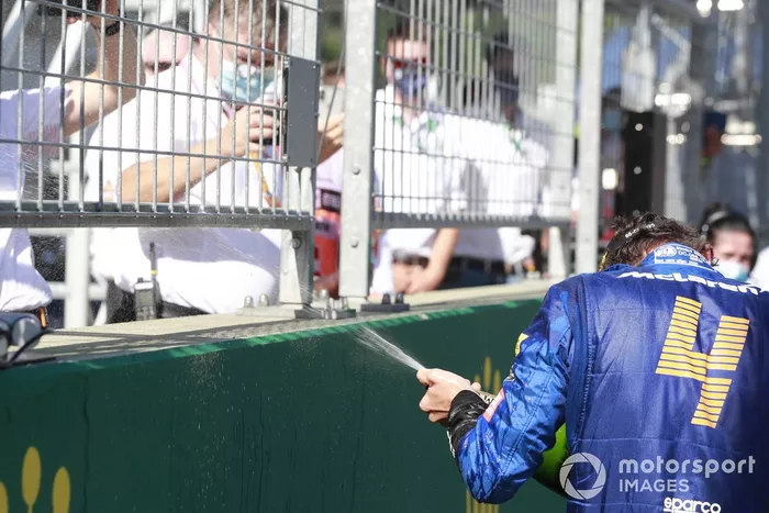 Lando Norris, McLaren, spruzza lo champagne sul podio