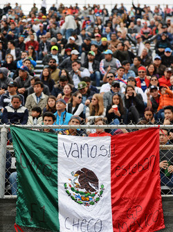 Fans en la tribuna y una bandera mexicana