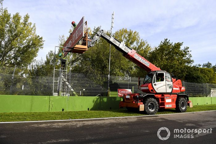 Los trabajadores de mantenimiento colocan algunos letreros de patrocinadores