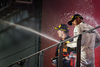 Lewis Hamilton, Mercedes AMG F1, and Max Verstappen, Red Bull Racing, celebrate on the podium with champagne