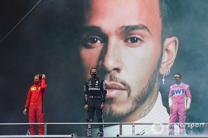 Lewis Hamilton, Mercedes-AMG F1, on the podium after winning the race, to take his 7th World Championship title, with Sergio Perez, Racing Point, 2nd position, and Sebastian Vettel, Ferrari, 3rd position