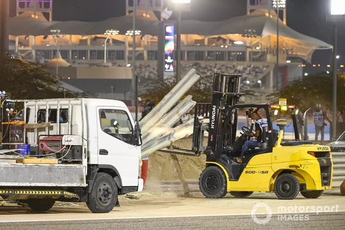 Los oficiales retiran los restos después del choque de Romain Grosjean, Haas VF-20, en la primera vuelta