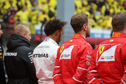 Valtteri Bottas, Mercedes AMG, Lewis Hamilton, Mercedes AMG, Sebastian Vettel, Ferrari, and Kimi Raikkonen, Ferrari, join the other drivers on the grid for the national anthem