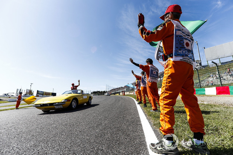 Marshals line the track as Kimi Raikkonen, Ferrari, passes in the drivers parade