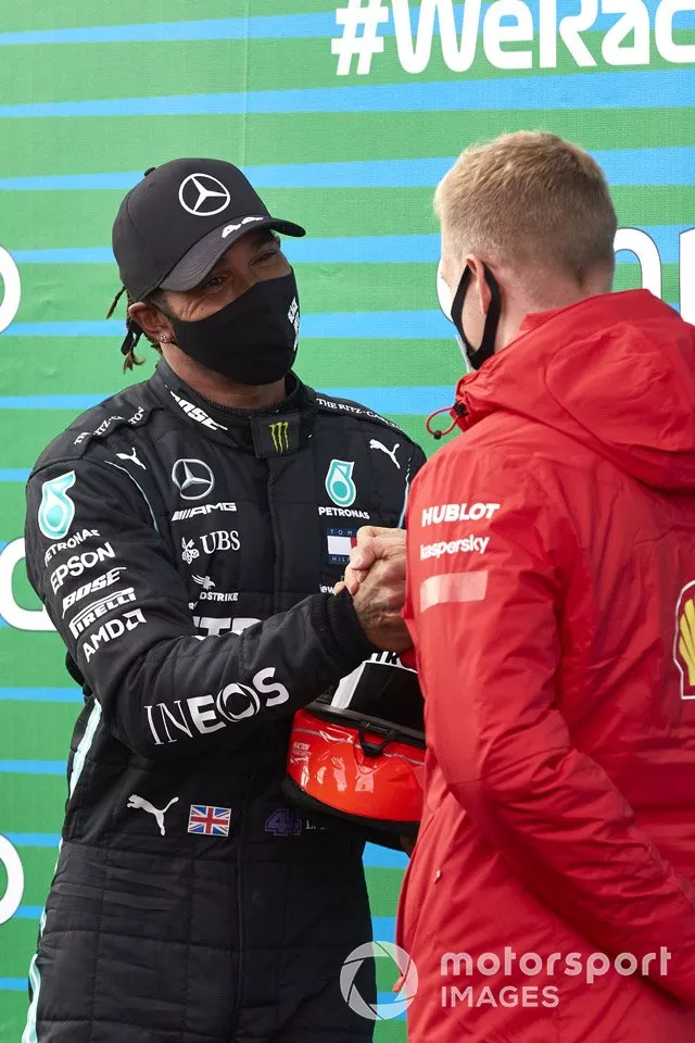 Mick Schumacher entrega a Lewis Hamilton, Mercedes-AMG F1, el casco de su padre después de que el piloto de Mercedes igualara el récord de Michael Schumacher de 91 victorias en carreras