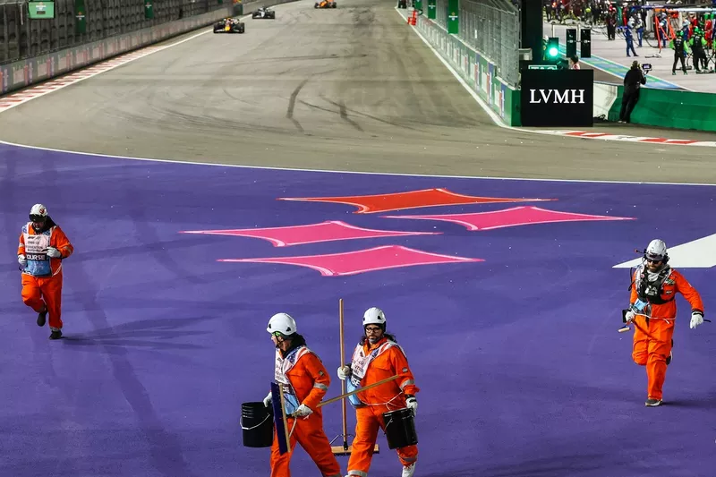 Les commissaires nettoient les débris sur la piste