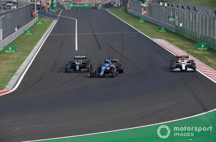 Esteban Ocon, Alpine A521, Sebastian Vettel, Aston Martin AMR21, mientras giran Antonio Giovinazzi, Alfa Romeo Racing C41