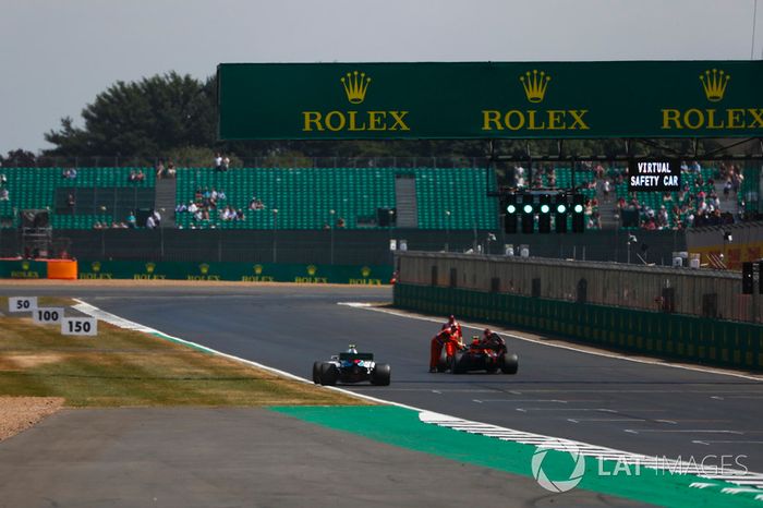Sergey Sirotkin, Williams FW41, passes as marshals move the car of Max Verstappen, Red Bull Racing RB14