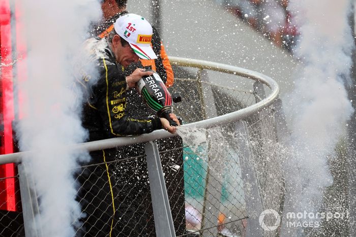Charles Leclerc, Scuderia Ferrari, 1ª posición, rocía champán a los aficionados en celebración 