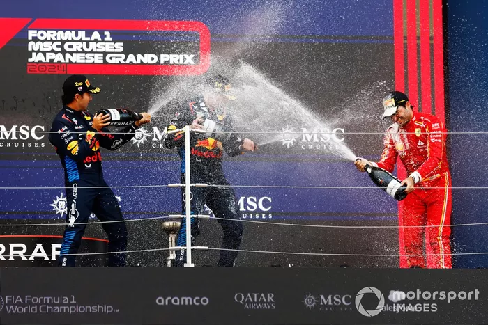 Sergio Perez, Red Bull Racing, 2e position, Max Verstappen, Red Bull Racing, 1re position, Carlos Sainz, Scuderia Ferrari, 3e position, célèbrent avec du champagne sur le podium.