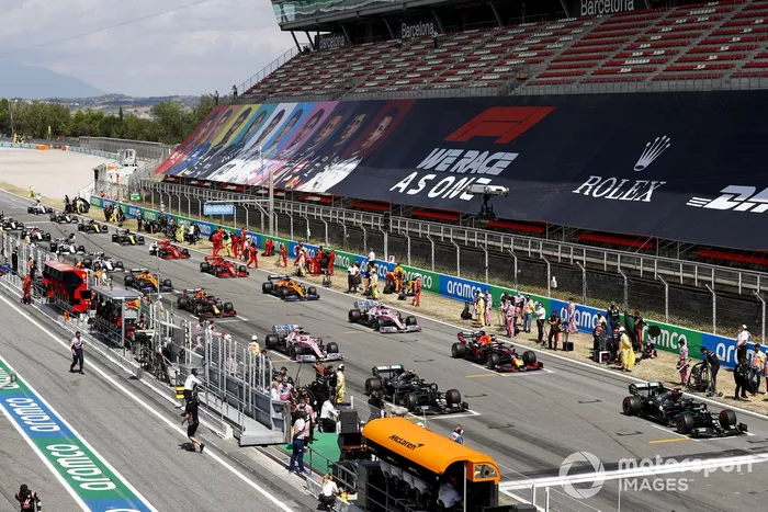 Los mecánicos despejan la parrilla mientras los pilotos se preparan para iniciar la vuelta de formación