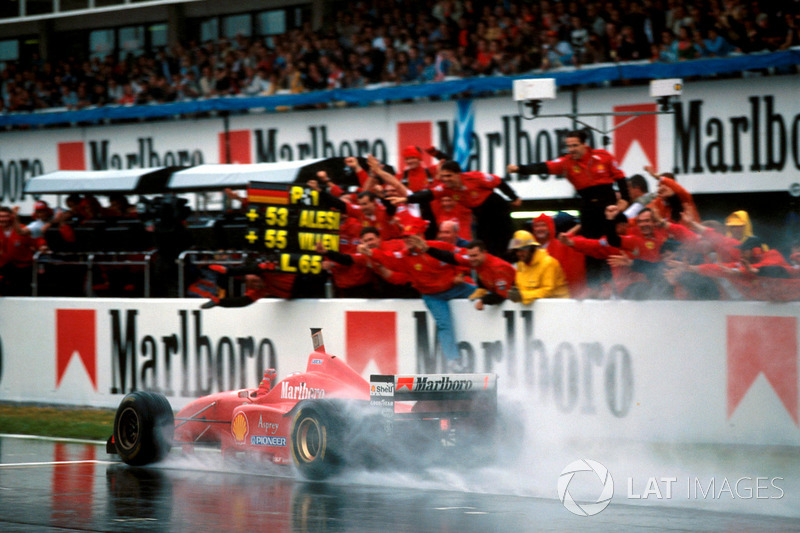 Winnaar Michael Schumacher, Ferrari F310 komt over de finishlijn