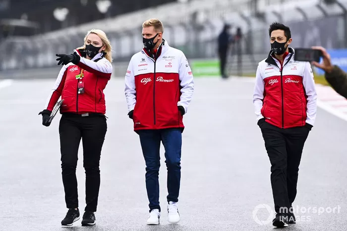 Mick Schumacher, Alfa Romeo, recorre la pista con miembros del equipo