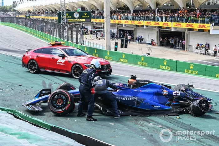 Delegados médicos de la FIA asisten a Alex Albon, Williams FW45, tras un choque en la salida con Kevin Magnussen, Haas VF-23