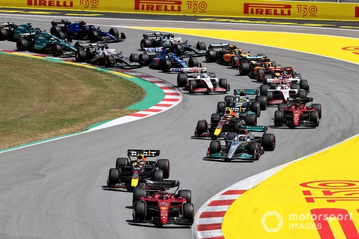 Charles Leclerc, Ferrari F1-75, Max Verstappen, Red Bull Racing RB18, George Russell, Mercedes W13, Sergio Pérez, Red Bull Racing RB18, Carlos Sainz, Ferrari F1-75, Lewis Hamilton, Mercedes W13, Kevin Magnussen, Haas VF-22, Mick Schumacher, Haas VF-22, y el resto de la parrilla en la vuelta inicial