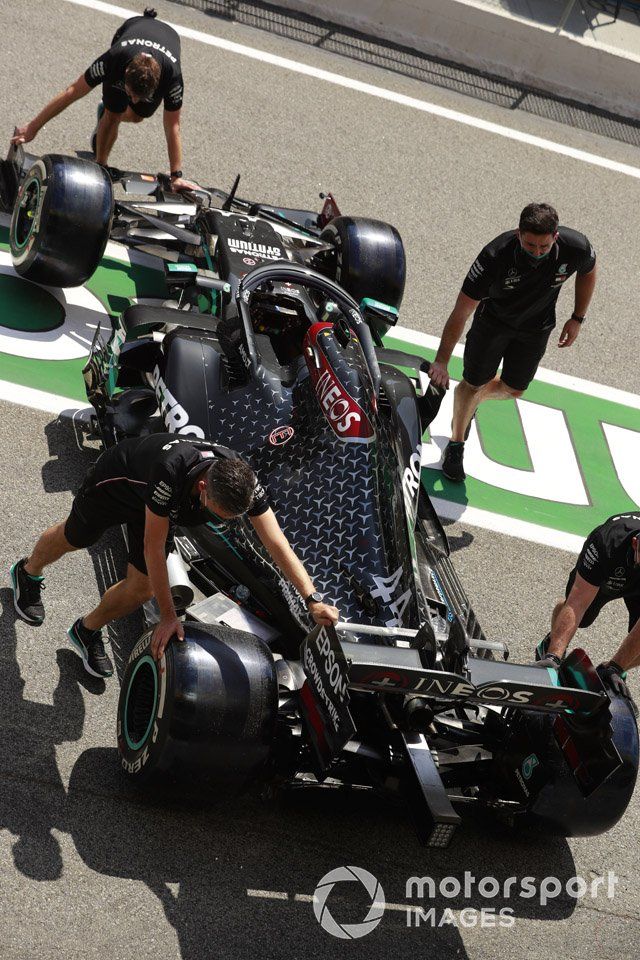 Los mecánicos empujan el monoplaza de Lewis Hamilton, Mercedes F1 W11 EQ Performance, en el pit lane
