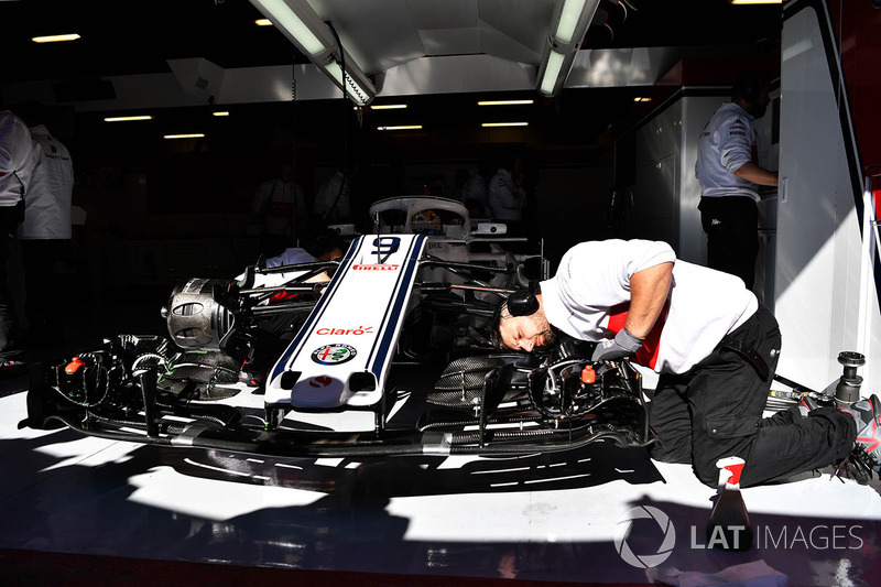 Mechanics work on Alfa Romeo Sauber C37 in the garage