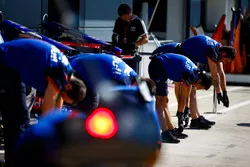 Toro Rosso mechanics perform stretching exercises