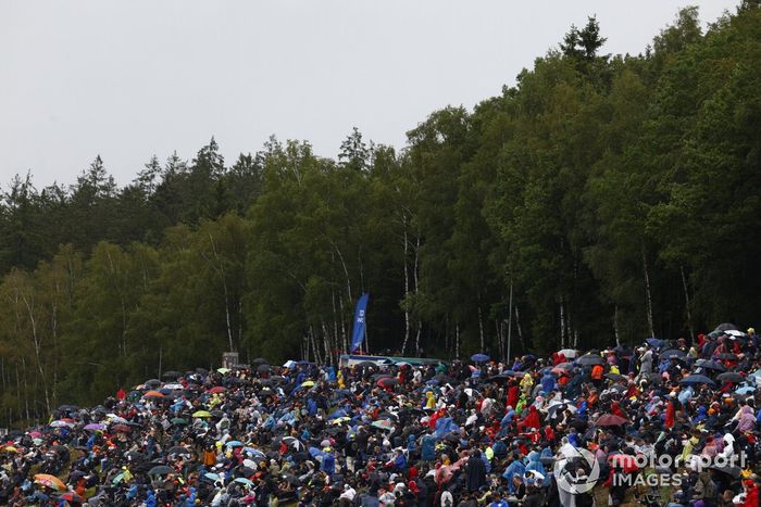 Aficionados con paraguas en algunos bancos