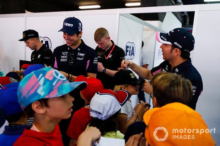 Kevin Magnussen, Haas F1, Lance Stroll, Racing Point, y Sergio Pérez, Racing Point, firman autógrafos para los jóvenes aficionados