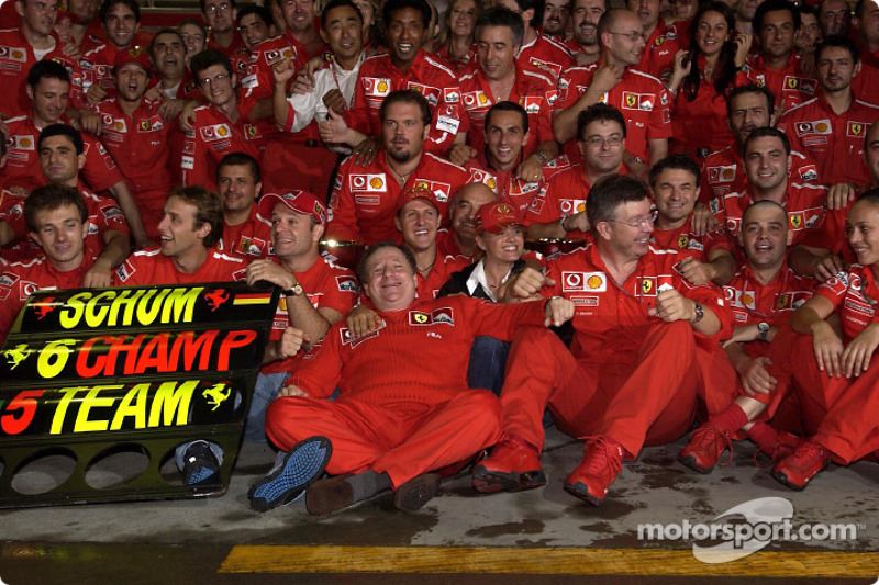 Michael Schumacher and Rubens Barrichello celebrate with Ferrari team members