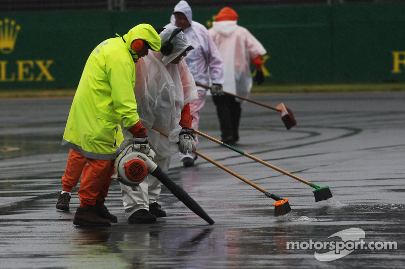 Marshals clear the track of rain water