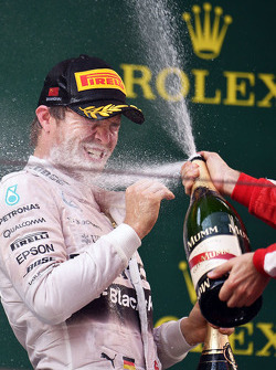 Нико Росберг Mercedes AMG F1 празднует свое второе место на подиуме с шампанским