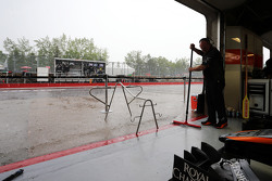 Un mécanicien Force India protège le garage de la pluie