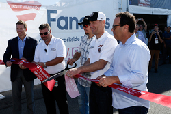 Martin Truex Jr. and Kevin Harvick cup the ribbon to officially open the NASCAR Trackside Superstore