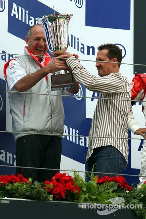 Michael Schumacher da la mano a Ron Dennis y el trofeo de constructores