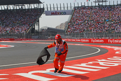 Ein Sportwart räumt Trümmerteile von Sebastian Vettel, Ferrari, weg