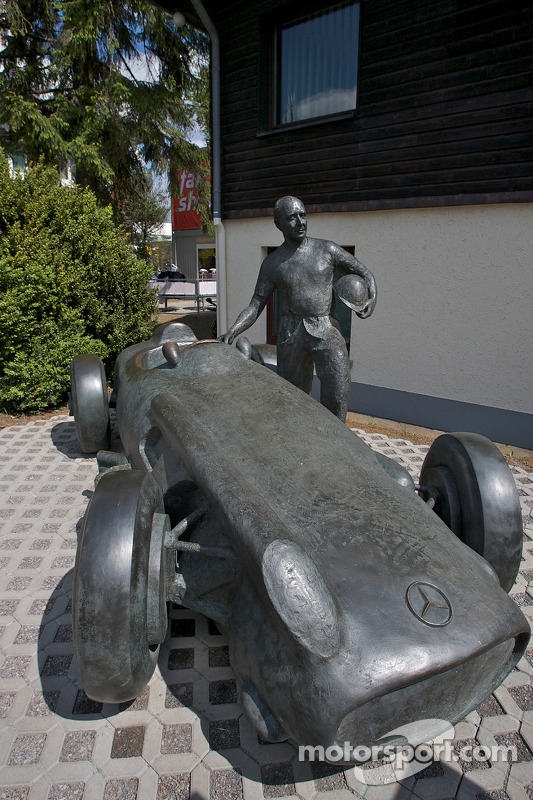 Una estatua de bronce de Juan Manuel Fangio y su Mercedes-Benz W196 en la entrada de la pista