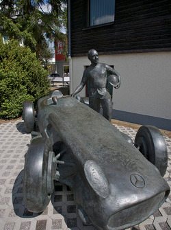 Una estatua de bronce de Juan Manuel Fangio y su Mercedes-Benz W196 en la entrada de la pista