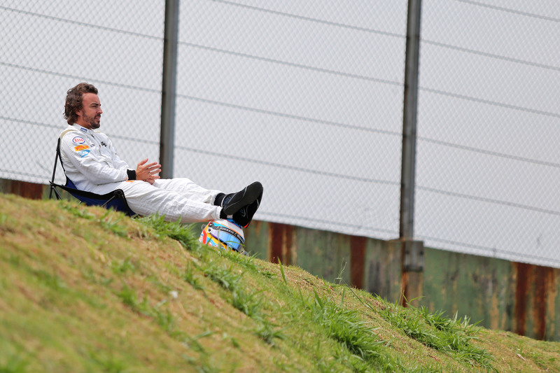 Fernando Alonso observa la clasificación sentado en una silla a un lado del circuito después de abandonar