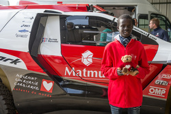 Samba, un enfant sénégalais sauvé par Mécénat Chirurgie Cardiaque, avec le Peugeot 2008 DKR15+ de Romain Dumas et François Borsotto